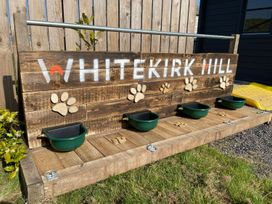 A wooden structure with paw prints and water bowls at Whitekirk Hill North Berwick