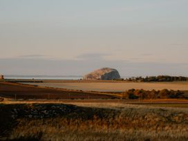 A landscape with a mountain and fields near the ocean at The Irvine in North Berwick