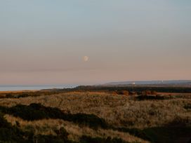 A view of the ocean and fields with a moon in the sky at The Irvine in North Berwick