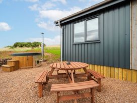 An outdoor area with a hot tub and a wooden table with benches at The Townsend in North Berwick