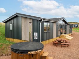 A modern cabin with a hot tub and outdoor seating at The Townsend in North Berwick