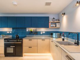 A kitchen with a cooker, sink, and storage cabinets at The Laidlaw Spa in North Berwick