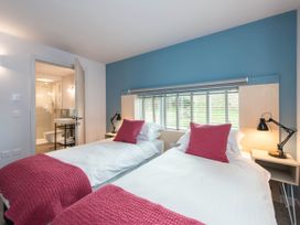A bedroom with two single beds and a bathroom visible at The Laidlaw Spa in North Berwick