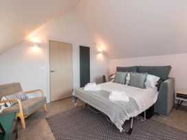 A bedroom with a bed and chair at The Laidlaw Spa in North Berwick