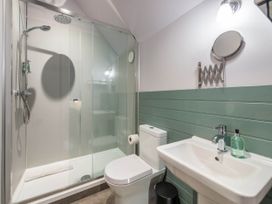 A bathroom with shower, toilet, sink, and mirror at The Laidlaw Spa in North Berwick