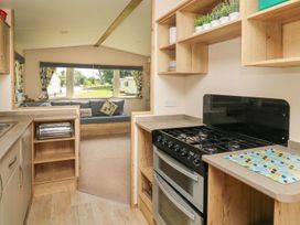 A kitchen with a gas stove and sink at Caravan 6 at Blackmoor Farm near tenby