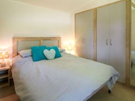 A bedroom with a bed and wardrobe at Caravan 6 at Blackmoor Farm near tenby Narberth