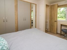 A bedroom featuring a bed and wardrobe at Caravan 6 at Blackmoor Farm near tenby