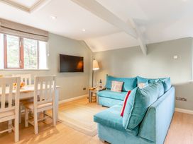 A living room with a sofa and dining area at Crabtree Cottage in Bude