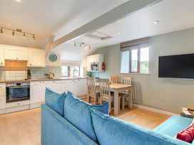 A kitchen with a sofa and dining area at Crabtree Cottage in Bude