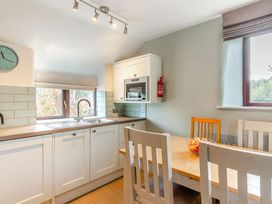 A kitchen with a sink and dining area at Crabtree Cottage in Bude