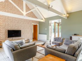 A living room with a television, sofas, and coffee table at Godolphin Stable in Bude