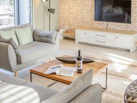 A living room with a sofa and coffee table at Godolphin Stable in Bude