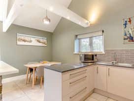 A kitchen with a table and chairs at Godolphin Stable Bude