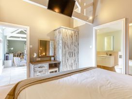 A bedroom with a bed and a wardrobe at Godolphin Stable Bude