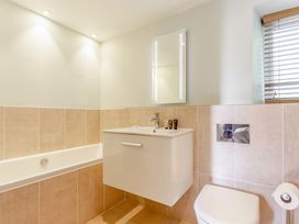 A bathroom with a bathtub, sink, and toilet at Godolphin Stable in Bude