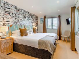 A bedroom with a bed and window at Godolphin Stable in Bude