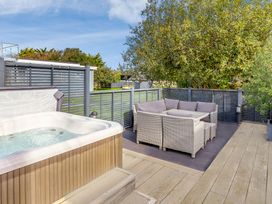 An outdoor area with a hot tub and seating at Godolphin Stable Bude