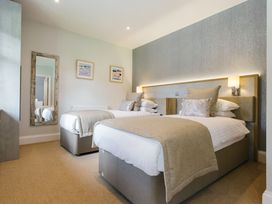 A bedroom with two beds and a mirror at Cornish Lodge Spa in Bude