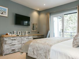 A bedroom with a television and dresser at Cornish Lodge Spa in Bude