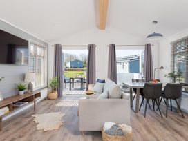 A living room with a sofa and dining table at Kynance Spa (Pet) Bude