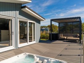 An outdoor area with a hot tub and seating at Mullion 2 Spa in Bude
