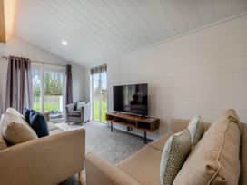 A living room with a television and sofa at Mullion 2 Spa in Bude