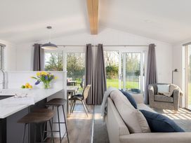 A living room with a sofa and kitchen island at Mullion 2 Spa in Bude