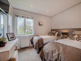A bedroom with two beds and a television at Sennen 2 Spa Roof Terrace (Pet) Bude