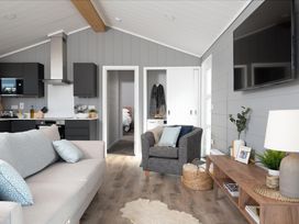 A living room with a sofa and television at Kynance (Pet) in Bude