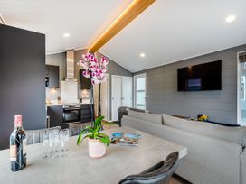 A living room with a dining table and kitchen area at Kynance (Pet) in Bude