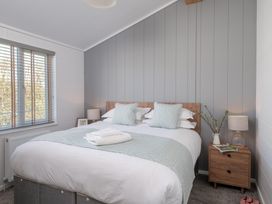 A bedroom with a bed and bedside table at Kynance (Pet) Bude