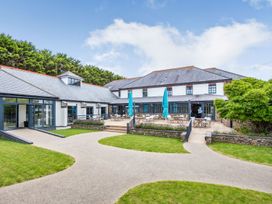 An outdoor area with seating and umbrellas at Kynance (Pet) Bude