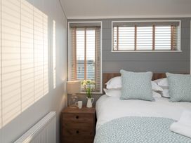A bedroom with a bed and bedside table at Mullion 2 Spa (Pet) Bude