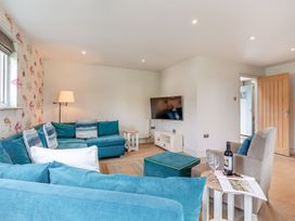 A living room with a television and sofa at Summerleaze Garden Cottage 3 Spa Bude
