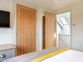 A bedroom with a bed and doors at Summerleaze Garden Cottage 3 Spa Bude