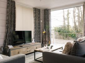 A living room with a television and sofa at The Glasshouse in Bude