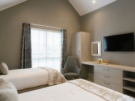 A bedroom with two beds and a television in The Glasshouse in Bude