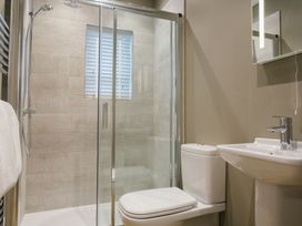 A bathroom featuring a shower, toilet, and sink at The Glasshouse in Bude
