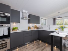 A kitchen with cabinets and appliances at Mullion Spa in Bude