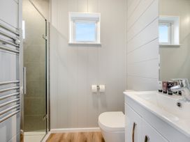 A bathroom with a shower, toilet, and sink at Mullion Spa in Bude