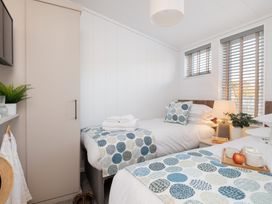A bedroom with two beds and a lamp at Mullion Spa in Bude