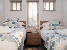 A bedroom with two beds and a bedside table at Mullion Spa in Bude