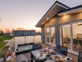 An outdoor dining area with a hot tub at Mullion Spa (Pet) in Bude
