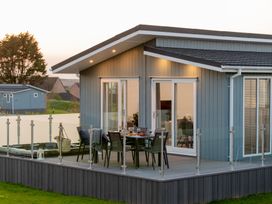 A house with a deck, table and chairs at Mullion Spa (Pet) Bude