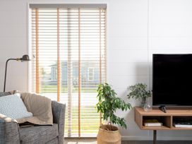 A living room with a sofa, lamp, and television at Mullion Spa (Pet) in Bude
