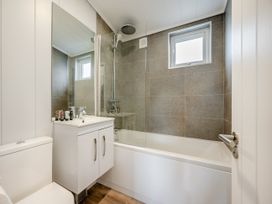 A bathroom with a bathtub, sink, and toilet at Mullion Spa (Pet) Bude