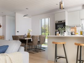 A kitchen with a dining area and appliances at Sennen 3 Spa Roof Terrace (Pet) Bude