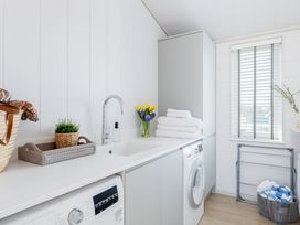 A laundry room with a washing machine and a sink at Sennen 3 Spa Roof Terrace (Pet) Bude