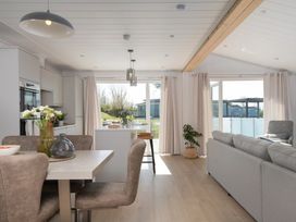 A living room with a dining area and kitchen cabinets at Sennen 3 Spa (Pet) in Bude